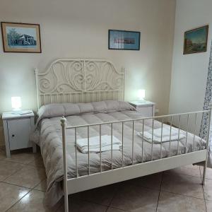 a white bed in a bedroom with two night stands at Nonnacettyhouse in Torre del Greco
