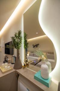 a kitchen with a counter with vases and a mirror at Del Mare Rooms in Vlorë