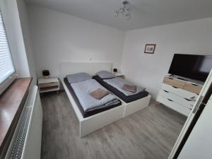 a bedroom with a bed and a flat screen tv at Schöne Ferienwohnung in Landsberg in Landsberg +4 photos
