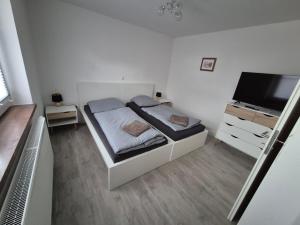 a small bedroom with a bed and a television at Schöne Ferienwohnung in Landsberg in Landsberg