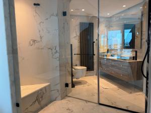 a bathroom with a glass shower and a toilet at SKYLINE SUITES Tunisia in Tunis +6 photos