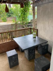 a black table and benches on a patio at Pap De Home in Weligama