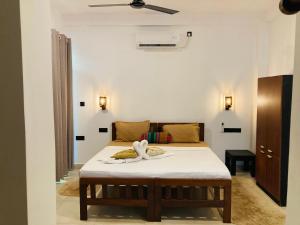 a bedroom with a bed with a swan on it at Seashore Mirissa in Mirissa +44 photos