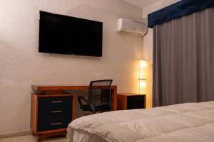 a hotel room with a bed and a desk and a television at Tribe Boutique Resort by Mega Stays in Guayacanes +133 photos