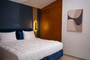 a bedroom with a large bed with a blue headboard at Tribe Boutique Resort by Mega Stays in Guayacanes