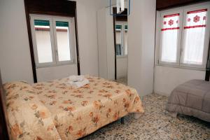 a bedroom with a bed and two windows at La terrazza in Contursi