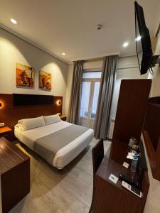 a hotel room with a bed and a desk at Hostal Cervelo in Madrid