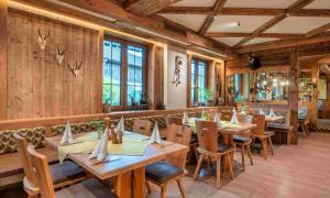 ein Restaurant mit Holzwänden, Tischen und Stühlen in der Unterkunft lustiger Hirsch in Akams