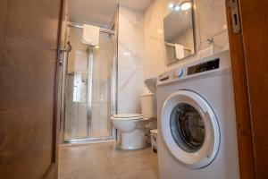 a bathroom with a washing machine and a toilet at Stillel Retreat Suites in St. Paul's Bay