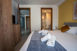 a bedroom with a bed with towels on it at Stillel Retreat Suites in St. Paul's Bay