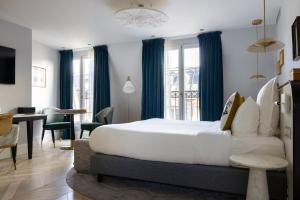 a bedroom with a large bed and a dining room at Normandy Le Chantier in Paris