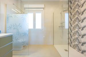 a bathroom with a shower with a glass door at Villa Cronos - PlusHolidays in Ifach +86 photos