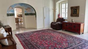 a living room with a chair and a rug at Csillaghy Kastély in Bókaháza