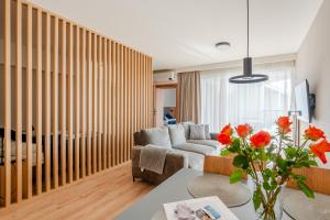 a living room with a couch and a table at Akces APARTAMENTY KASPROWICZA 20C- BASEN, SAUNY, JACUZZI, SIŁOWNIA W CENIE - SCHWIMMBAD, SAUNEN, JACUZZI, FITNESSSTUDIO IM PREIS in Kołobrzeg