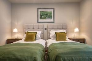 two beds sitting next to each other in a bedroom at Beckside in Kettlewell