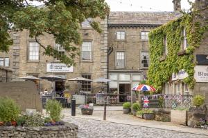 a building with umbrellas and tables in front of it at Beckside in Kettlewell