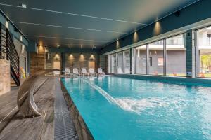 a pool with a water slide in a building at Akces APARTAMENTY KASPROWICZA 20C- BASEN, SAUNY, JACUZZI, SIŁOWNIA W CENIE - SCHWIMMBAD, SAUNEN, JACUZZI, FITNESSSTUDIO IM PREIS in Kołobrzeg