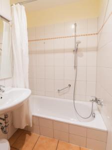 a bathroom with a shower and a tub and a sink at Hof Sierksdorf in Sierksdorf +30 photos