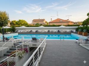 a large swimming pool with tables and chairs at RIVIERA PALACE - BILO SEA FRONT- Premium Villas in Giulianova
