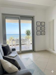a living room with a couch and a view of the ocean at RIVIERA PALACE - BILO SEA FRONT- Premium Villas in Giulianova +1 photo