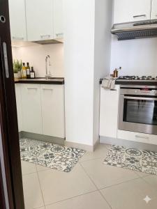 a kitchen with white cabinets and a tile floor at RIVIERA PALACE - BILO SEA FRONT- Premium Villas in Giulianova