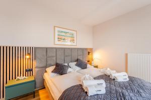a bedroom with a large bed with towels on it at Akces APARTAMENTY KASPROWICZA 20C- BASEN, SAUNY, JACUZZI, SIŁOWNIA W CENIE - SCHWIMMBAD, SAUNEN, JACUZZI, FITNESSSTUDIO IM PREIS in Kołobrzeg +50 photos