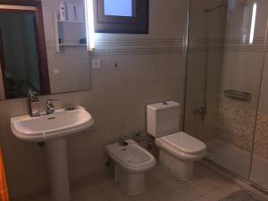 a bathroom with a sink and a toilet and a shower at Casa Corralejo a 40 m playa in Corralejo +7 photos