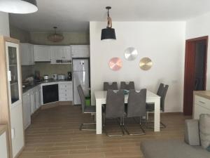 a kitchen and dining room with a table and chairs at Casa Corralejo a 40 m playa in Corralejo