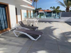 a patio with two lounge chairs and a table at Casa Corralejo a 40 m playa in Corralejo