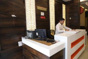 a man standing at a desk with a computer at Hotel Lav Kush Deluxe 2 Min Walk From New Delhi Railway Station in New Delhi