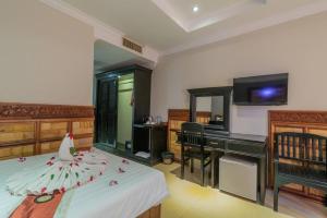 a bedroom with a bed and a desk and a piano at Dara Panha Sak Guesthouse in Siem Reap