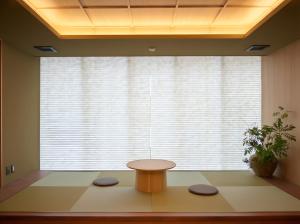 a room with a table in front of a large window at Apartment Hotel UCHIWA STAY Osaka NAMBA in Osaka