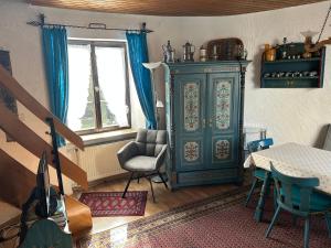 a living room with a blue cabinet and a chair at Turm an der Mauer in Ellwangen