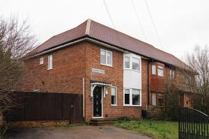 a red brick house with a black fence at Contractor friendly 3BDR Home | Parking for Vans in Salford