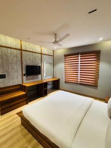 a large bedroom with a large bed and a flat screen tv at HR The nature resort in Birbhaddar