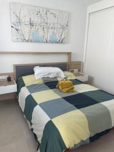 a bedroom with a bed with a blue and yellow blanket at Santa Rosalia Lake & Life resort in Torre-Pacheco +26 photos