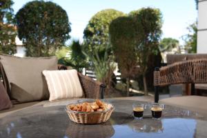a basket of bread sitting on a table with two drinks at Villa Beta 2 - 3min walk to Elephant and Mako in Pefkochori +69 photos