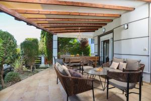 a patio with a wooden pergola and a table and chairs at Villa Beta 2 - 3min walk to Elephant and Mako in Pefkochori