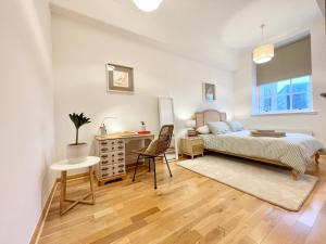a bedroom with a bed and a desk and a chair at Luxury Historic City-Centre Flat & Free Parking in Glasgow
