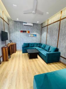 a living room with a blue couch and a tv at HR The nature resort in Birbhaddar