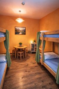 a room with two bunk beds and a table at Jopi Hostel Katowice Centrum in Katowice