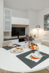a white table with plates of food on it at Brezza di Mare Apartment in Scanzano
