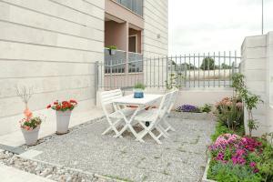 a table and two chairs on a patio with flowers at Brezza di Mare Apartment in Scanzano