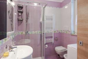 a pink bathroom with a sink and a toilet at Brezza di Mare Apartment in Scanzano