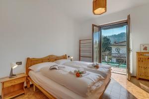 a bedroom with two beds and a large window at Villa Eva: Leggiuno 5-Bed Villa for Families & Groups (Sleeps 10) - Happy Rentals in Leggiuno