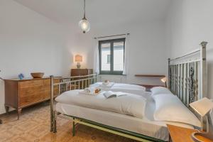 a bedroom with a large bed with white sheets at Villa Eva: Leggiuno 5-Bed Villa for Families & Groups (Sleeps 10) - Happy Rentals in Leggiuno