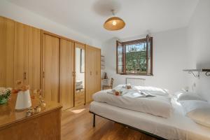 a bedroom with a large white bed and a window at Villa Eva: Leggiuno 5-Bed Villa for Families & Groups (Sleeps 10) - Happy Rentals in Leggiuno +37 photos