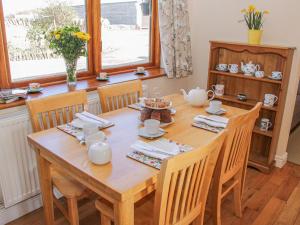 a dining room with a wooden table and chairs at Herdwick Cottage in Much Wenlock +19 photos