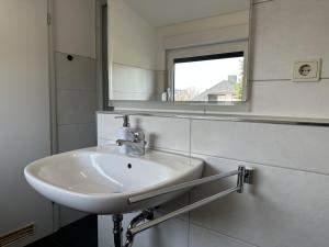 a white sink in a bathroom with a mirror at Gästehaus Elzblick in Rust
