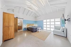 a bedroom with a bed and a couch and a table at Koeriboeri Aruba Lodges in Babijn +96 photos